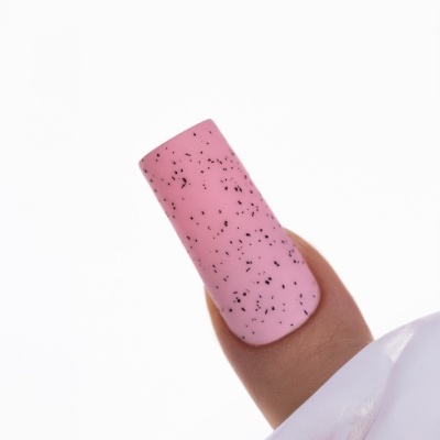 Unha rosa claro com manchas pretas segurando tecido branco