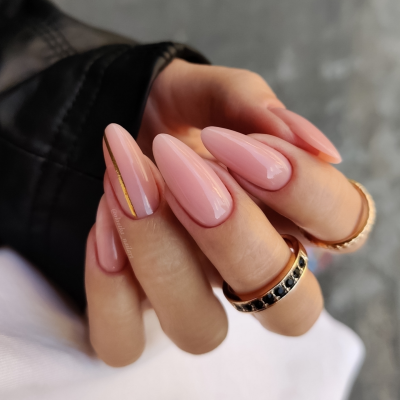 Unhas postiças compridas em rosa claro com decoração dourada e anéis dourados com pedras pretas