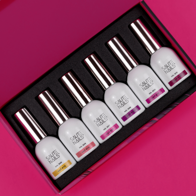 Conjunto de seis vernizes Saute Nails com tampas prateadas em caixa rosa aberta