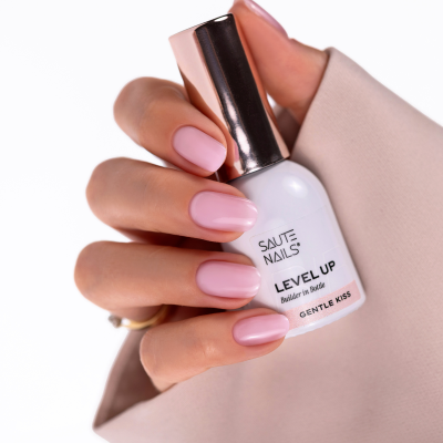 Mão com unhas rosas segurando frasco de verniz SAUTE NAILS LEVEL UP