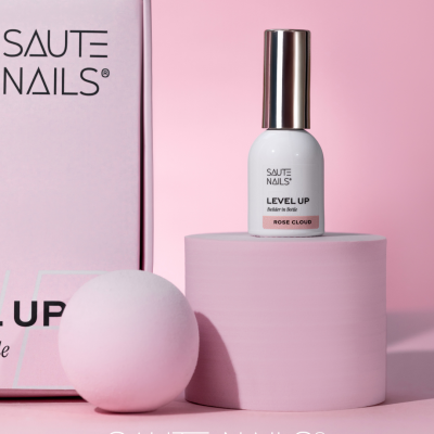 Frasco branco de verniz de unhas SAUTE NAILS na cor Rose Cloud sobre plataforma rosa