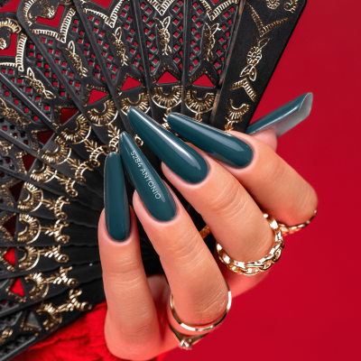 Mão com unhas azul-escuro segurando leque negro dourado