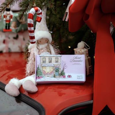 Caixa de verniz de unhas de coleção de inverno sobre carro vermelho com decoração natalícia