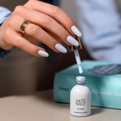 Frasco de verniz SAUTE NAILS branco com pincel e mão com unhas pintadas de branco