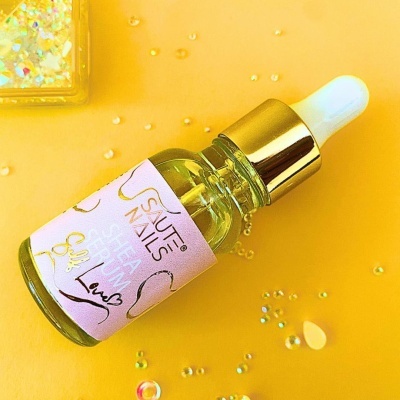 Frasco de sérum para unhas com conta-gotas sobre fundo amarelo com glitter