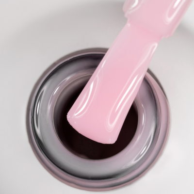 Verniz de unhas rosa pastel com pincel molhado dentro do frasco