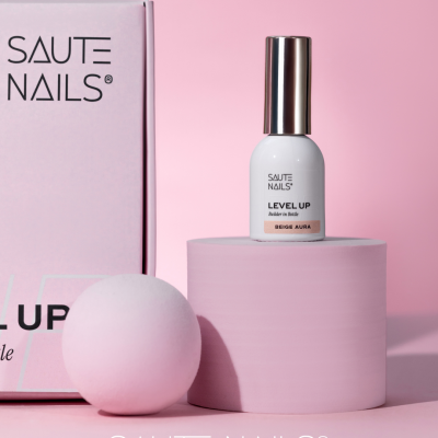 Verniz para unhas Saute Nails Beige Aura sobre suporte rosa com caixa rosa ao lado