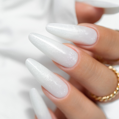 Unhas compridas com gel branco perolado e anel dourado