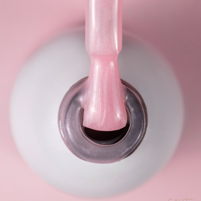 Pincel com verniz rosa perolado sobre frasco branco de verniz de unhas aberto