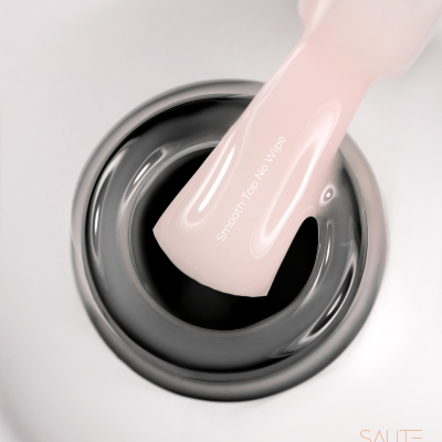 Frasco aberto de verniz de unhas preto com amostra rosa e texto 'Smooth Top No Wipes'.