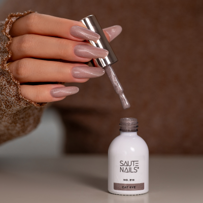 Verniz SAUTE NAILS Nº 813 em copo branco com pincel e unhas pintadas rosa cintilante