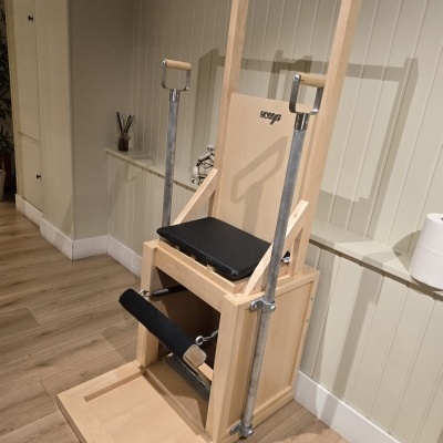 Cadeira de exercício em madeira com barras metálicas e assento preto