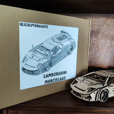 Modelo de carro de madeira junto a caixa de cartão com etiqueta de Lamborghini Murcielago
