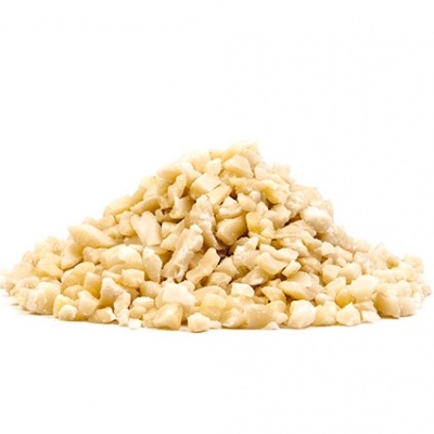 Pedacinhos pequenos de noz bege clara num montão sobre fundo branco