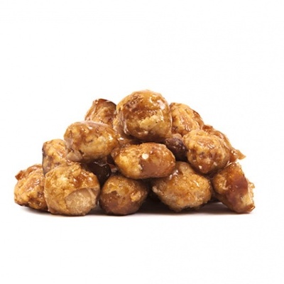 Amendoins caramelizados empilhados sobre fundo branco