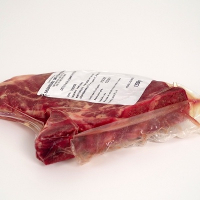Peça de carne crua embalada a vácuo com etiqueta branca