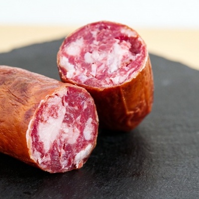 Chouriço cortado ao meio em superfície preta