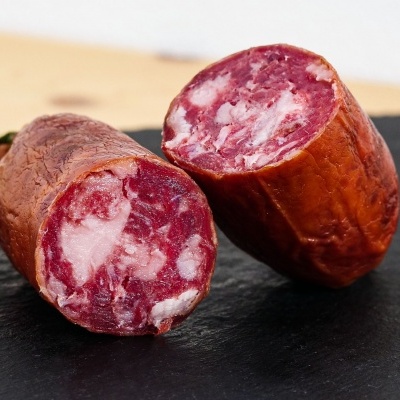 Salpicão tradicional cortado ao meio sobre placa de ardósia