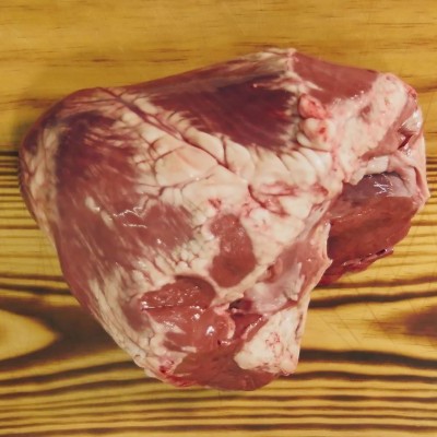 Peça de carne crua vermelha sobre tábua de madeira
