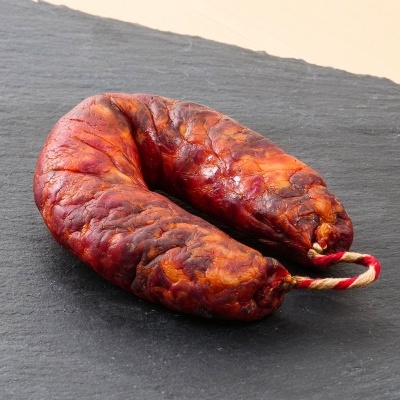 Chouriço seco castanho-avermelhado sobre ardósia preta