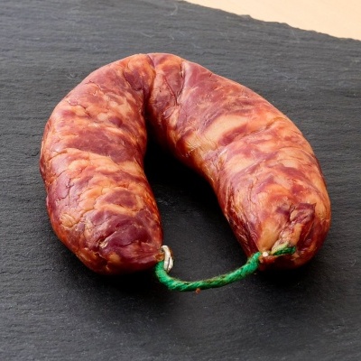 Chouriço tradicional em forma de ferradura sobre superfície preta