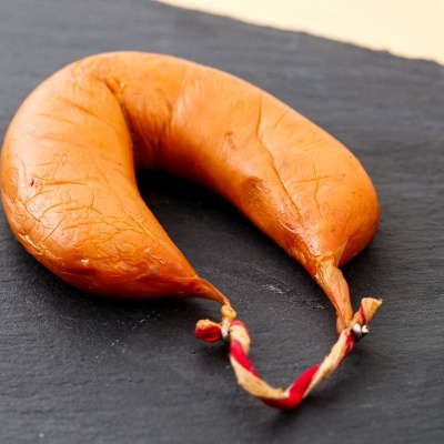 Chouriço curvado laranja-avermelhado sobre superfície preta