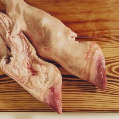 Cabeças de porco cru sobre tábua de madeira