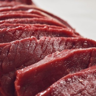 Fatias de carne vermelha crua alinhadas.