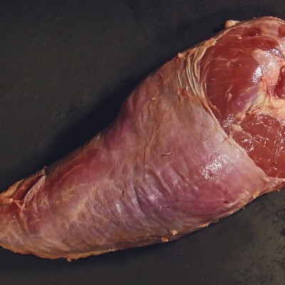 Pedaço grande de carne crua vermelha sobre superfície escura