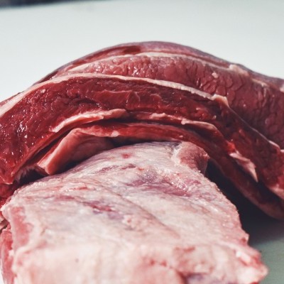 Pedaços de carne crua vermelha com gordura sobre superfície branca
