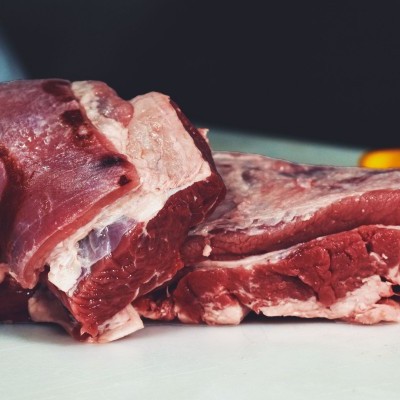 Pedaços de carne crua vermelha com gordura sobre superfície clara