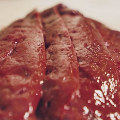 Peixe cru vermelho cortado fatias numa superfície branca