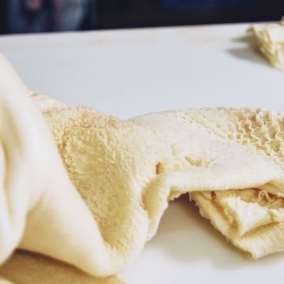 Toalha ou manta creme macia com textura felpuda sobre mesa branca