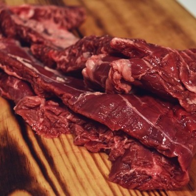 Tiras de carne crua vermelha sobre tábua de madeira