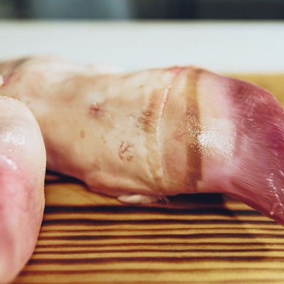 Língua de animal crua sobre tábua de madeira