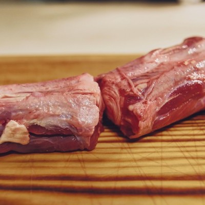 Pedaços de carne crua vermelha sobre tábua de madeira clara