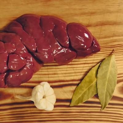 Rim cru vermelho, alho pequeno branco, folhas de louro verdes sobre madeira clara