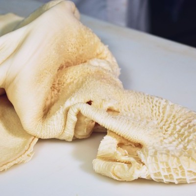 Peça de roupa bege claro com textura felpuda e padrão de almofadas quadradas