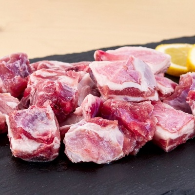 Pedaços de carne crua com fatias de limão sobre tábua preta