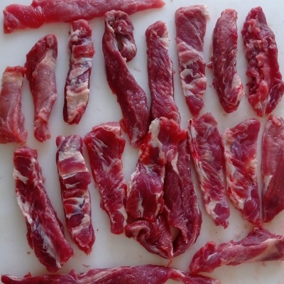 Pedaços de carne vermelha com gordura sobre superfície branca