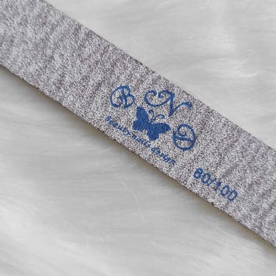 Lixa para unhas cinza com logotipo azul e número 800/100 sobre superfície branca