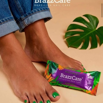Pés femininos com unhas verdes e embalagem BrazzCare pedicure kit
