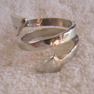 Anel prateado em espiral sobre tecido claro