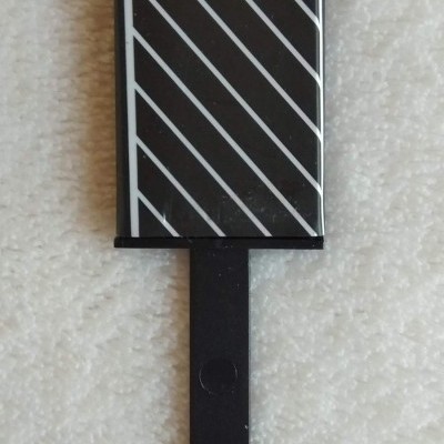 Dispositivo eletrónico preto com linhas diagonais brancas e cabo preto sobre tecido branco