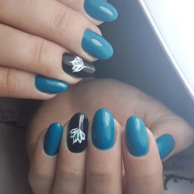 Unhas manicadas azul brilhante e preta com desenho branco