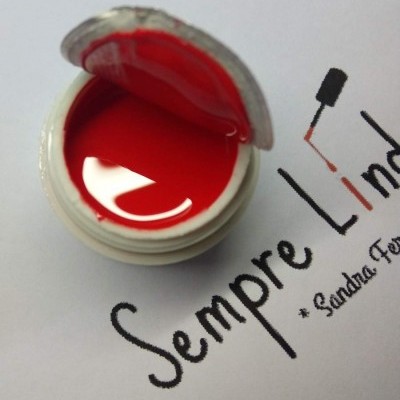 Pote aberto de tinta vermelha em papel com texto manuscrito