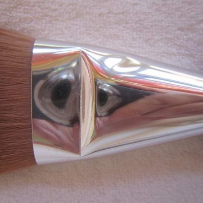 Pincel de maquilhagem com cabo preto e pega metálica brilhante