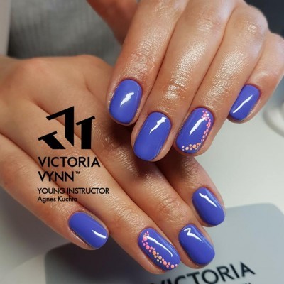 Mãos com unhas pintadas de azul com decoração rosa e texto Victoria Vynn