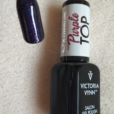 Frasco de verniz gel preto com tampa branca e amostra de cor roxo escuro brilhante