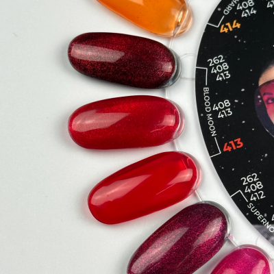 Amostras de verniz de unhas em tons de vermelho e laranja com disco preto ao lado